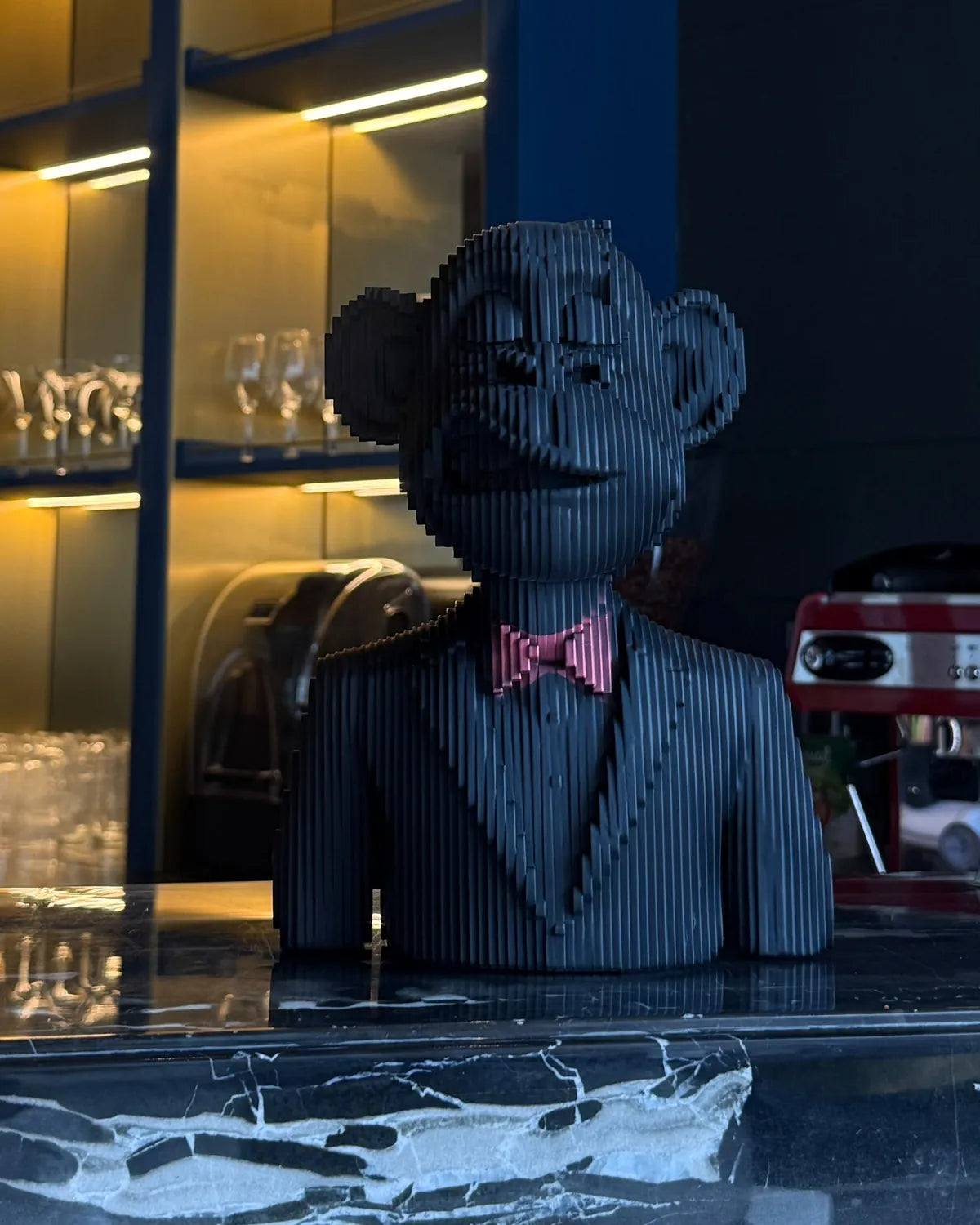 Money Move, the layered monkey bust with a pink bow tie, on a bar counter
